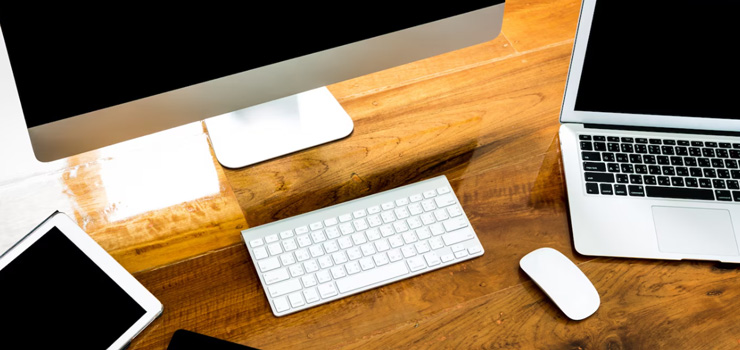 Computer, laptop and tablet view from above on a wooden table