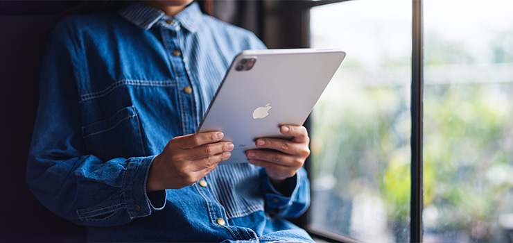 A woman holding and using an iPad at home