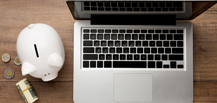 Laptop and piggy bank on a desk