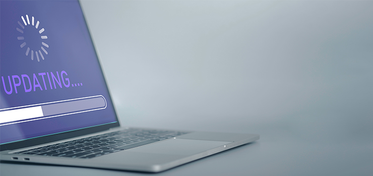 A laptop on a table showing a progress bar for an update