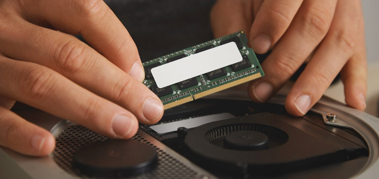 Close up of hands removing memory plate to upgrade computer