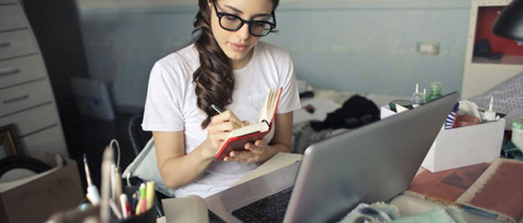 Woman using laptop on busy desk with hardly any space