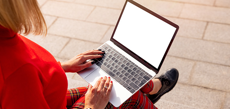 A woman’s hands typing in a MacBook