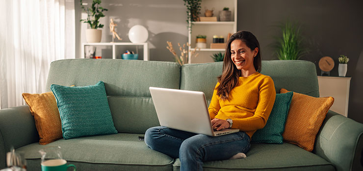Smiling woman using laptop at home